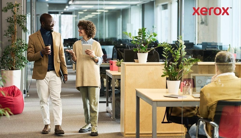 Zwei Berufstätige gehen und unterhalten sich in einem modernen Büro